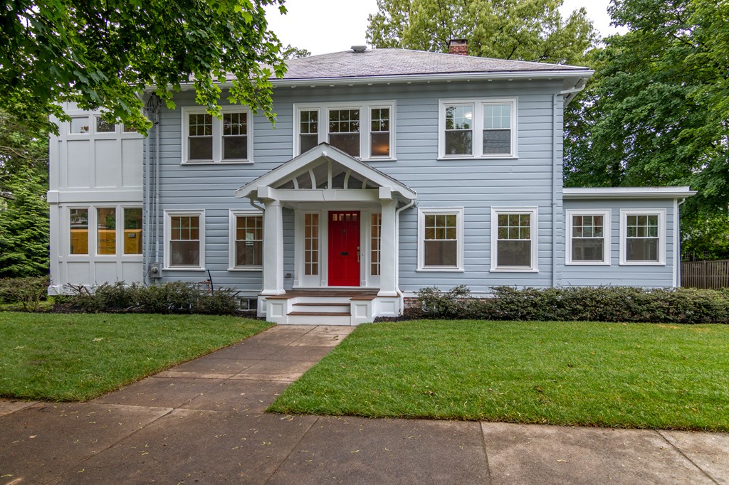 Exterior of 4-bed Colonial home at 63 Cedar Street, Newton MA with light blue siding and red door.